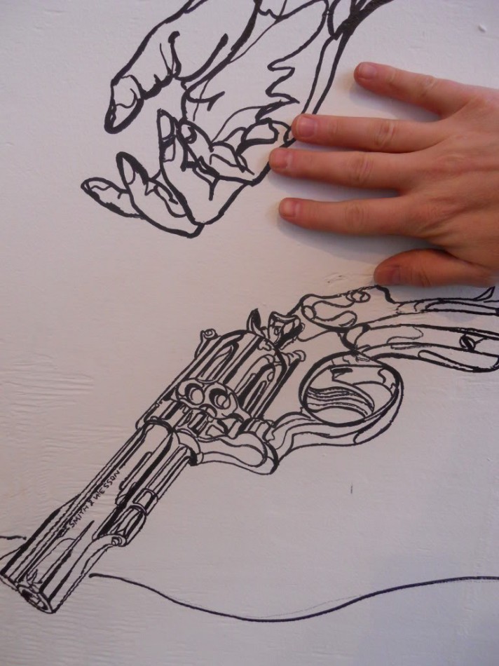Scale picture of gun and artist's hand