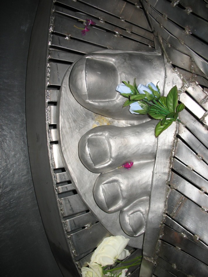 Detail of the Madonna's foot, with offerings